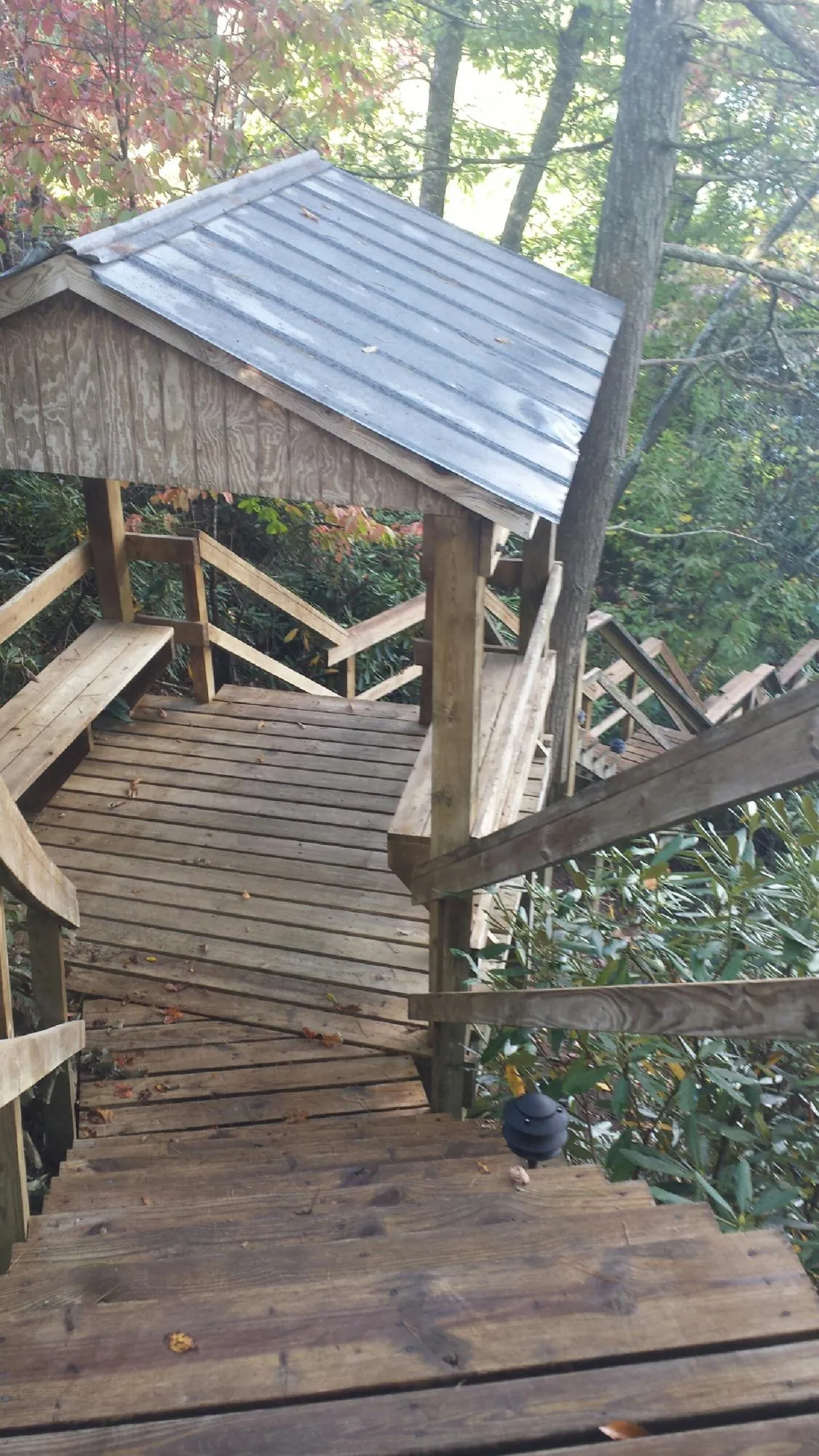 Metal roofed shelter over wooden steps on a wooded walkway — Skylight Repair & Installation work by our crew in Holland Patent
